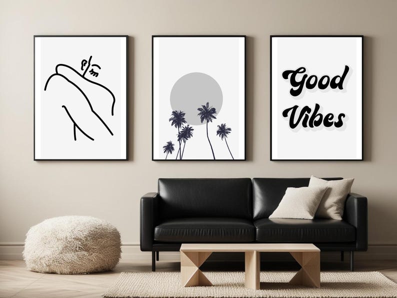 May include: Three framed art prints with black frames. The left print features a minimalist line drawing of a person. The center print shows palm trees in front of a gray sun. The right print says "Good Vibes" in black script.