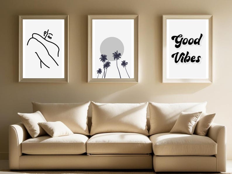 May include: Three framed art prints. The left print features a black and white line drawing of a person. The center print shows a gray sun and palm trees. The right print has the words "Good Vibes" in a black script font.