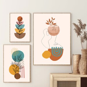 K&ouml;nnte beinhalten: Drei abstrakte Kunstdrucke im minimalistischen Stil. Die Drucke zeigen eine Kombination aus geometrischen Formen, Linien und organischen Elementen in Braun-, Gelb-, Orange-, Blau- und Rosat&ouml;nen. Die Drucke sind in einem hellen Holzrahmen gerahmt.