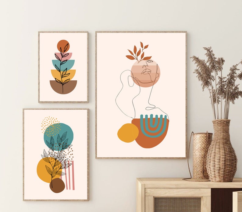 K&ouml;nnte beinhalten: Drei abstrakte Kunstdrucke im minimalistischen Stil. Die Drucke zeigen eine Kombination aus geometrischen Formen, Linien und organischen Elementen in Braun-, Gelb-, Orange-, Blau- und Rosat&ouml;nen. Die Drucke sind in einem hellen Holzrahmen gerahmt.
