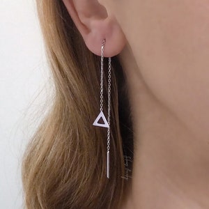 Può includere: Orecchini a catena d'argento con un ciondolo triangolare e una sottile barra che pende dal fondo.