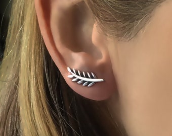 May include: A silver leaf shaped ear cuff earring. The earring is worn on the upper part of the ear.