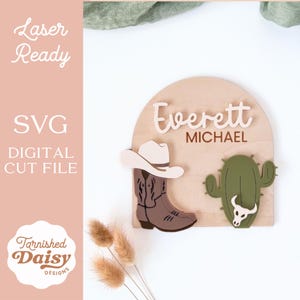 May include: Wooden sign with the name "Everett" and "Michael" in a Western theme. Features a cowboy boot, hat, and cactus with a skull. The sign is laser-ready and a digital cut file.