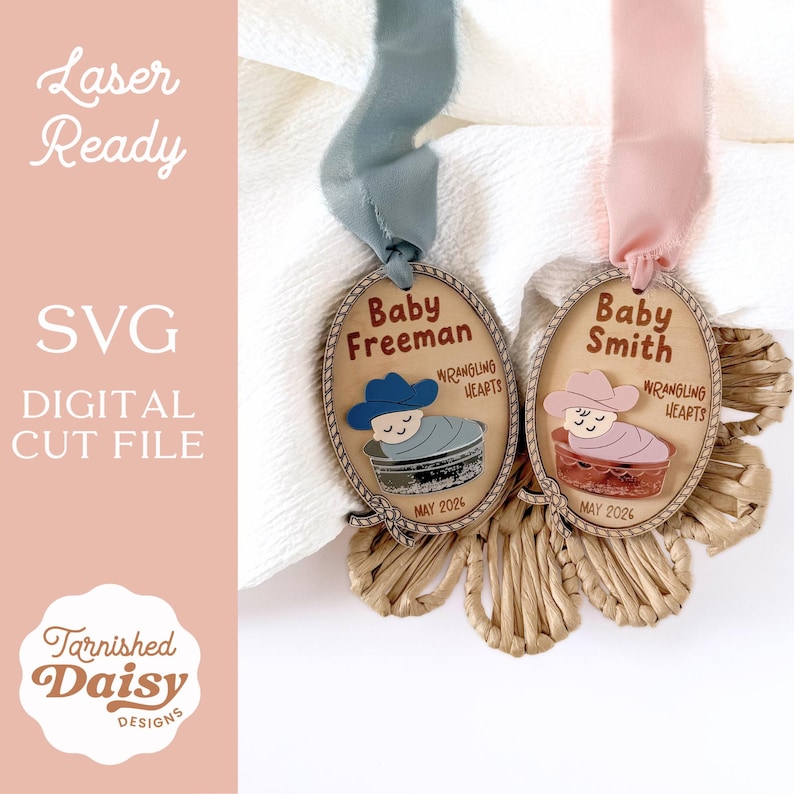 May include: Two wooden baby announcement tags with cowboy-themed illustrations. One tag features a blue cowboy hat and the name "Baby Freeman," while the other has a pink hat and "Baby Smith." Both include "Wrangling Hearts" and "May 2026."