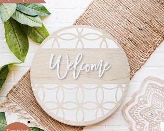May include: A round wooden door hanger with a white geometric pattern and the word "Welcome" in a white cursive font.