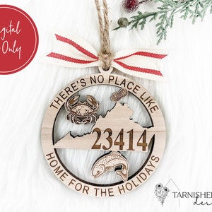 Op de afbeelding: Een houten ornament in de vorm van de staat Virginia met de tekst "THERE'S NO PLACE LIKE HOME FOR THE HOLIDAYS" en het nummer "23414" binnen de staatsgrens. De ornament heeft ook een krab, een vis en pinda's.