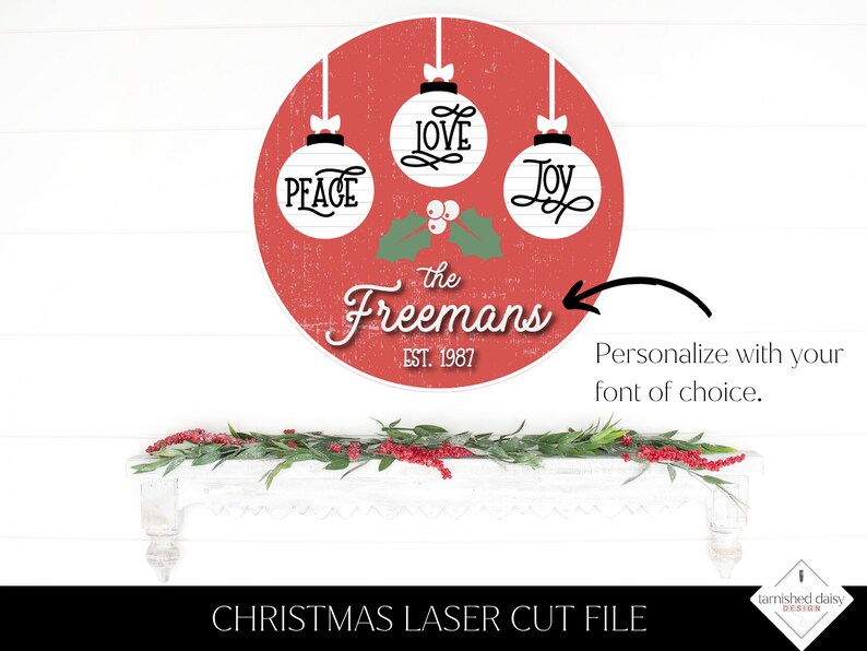 May include: Red circle with white ornaments that say "Peace", "Love", and "Joy" with holly and berries. The text "the Freemans Est. 1987" is below the ornaments.  This is a Christmas laser cut file.