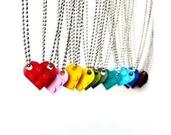 May include: A set of ten necklaces with heart-shaped charms made from LEGO bricks. The charms are in various colors, including red, pink, yellow, green, blue, and black. The necklaces are made with silver chains.