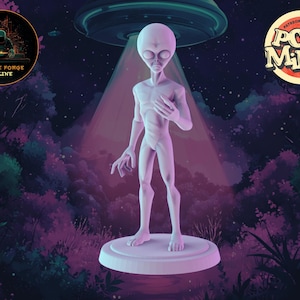 May include: A grey alien figurine standing on a white circular base. The alien has large eyes and a small mouth. The figurine is set against a dark background with a blurry image of a forest and a flying saucer in the background.