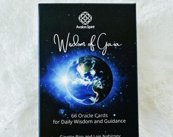 May include: A black box of "Wisdom of Gaia" oracle cards. The box features a cosmic design with an image of Earth. Text includes "66 Oracle Cards for Daily Wisdom and Guidance" and the authors' names.