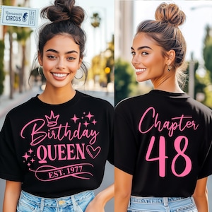 May include: Black t-shirt with pink text. The front reads "Birthday QUEEN EST. 1977" with a crown and stars. The back says "Chapter 48". The shirt is worn by a person.