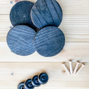 May include: Four black wooden coasters with a wood grain pattern and five black rubber furniture feet.