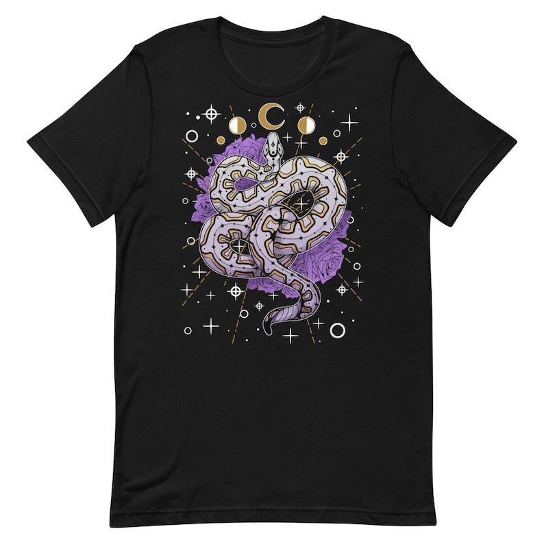 May include: Black t-shirt featuring a white and purple snake design. The snake is surrounded by purple roses and a celestial pattern of moons, stars, and circles.