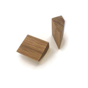 Könnte beinhalten: Zwei geometrische Formen aus Holz, ein Dreieck und ein Quadrat, beide in hellbrauner Farbe mit Holzmaserung.