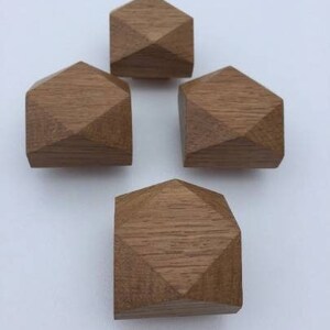 以下が含まれることがあります： ダイヤモンドの形をした木製の幾何学的な形が4つあります。 形は薄い茶色の木で作られており、滑らかで磨かれた仕上げになっています。