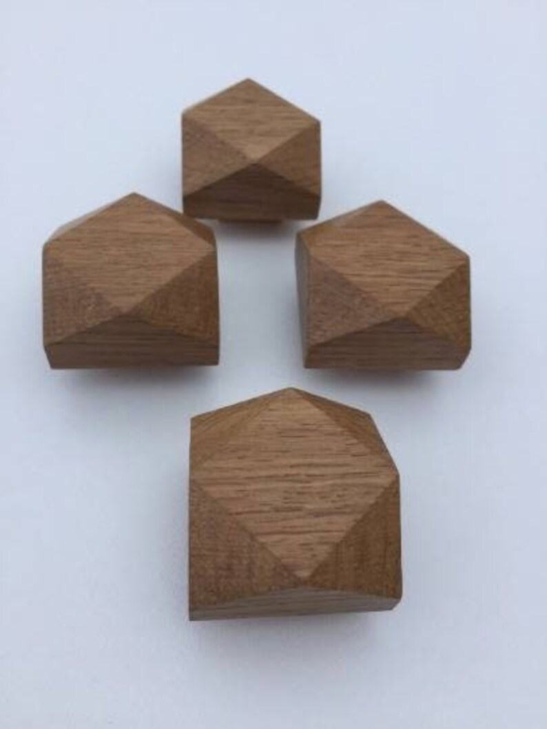 以下が含まれることがあります： ダイヤモンドの形をした木製の幾何学的な形が4つあります。 形は薄い茶色の木で作られており、滑らかで磨かれた仕上げになっています。
