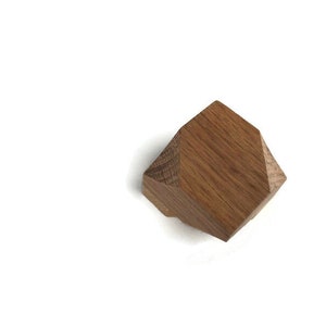 Puede incluir: Un pomo geom&eacute;trico de madera con forma hexagonal y acabado en madera natural.