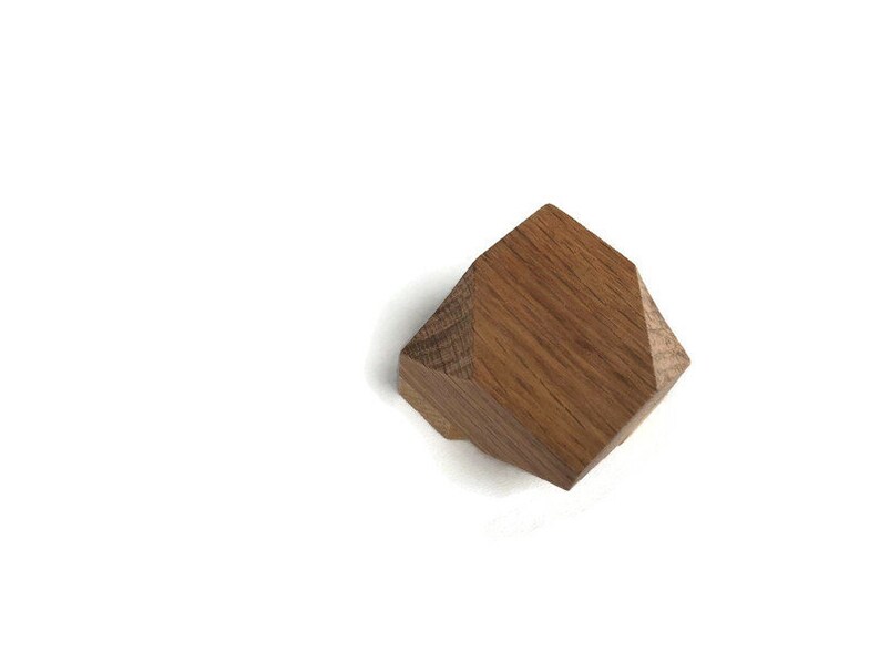 Puede incluir: Un pomo geom&eacute;trico de madera con forma hexagonal y acabado en madera natural.