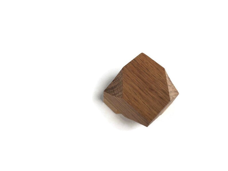 Puede incluir: Un pomo geom&eacute;trico de madera con forma hexagonal y color marr&oacute;n claro.