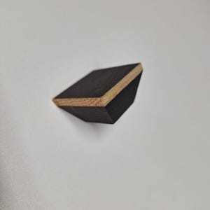 May include: A small, dark wood triangular shelf with a light wood edge.