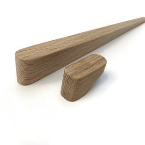 May include: Two wooden drawer pulls, one long and one short, made of light brown wood. The long pull is about 30 cm long and the short pull is about 7.5 cm long.