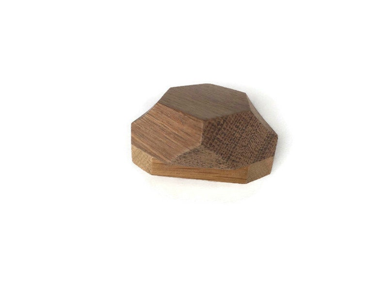 Puede incluir: Un pomo geom&eacute;trico de madera con un acabado marr&oacute;n. El pomo tiene un dise&ntilde;o facetado y est&aacute; formado como una piedra preciosa.