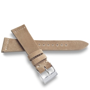 May include: A light brown suede watch strap featuring a textured matte finish, white contrast stitching near the lug end, two matching suede keepers, and a polished silver-tone metal buckle with a single prong for secure fastening.