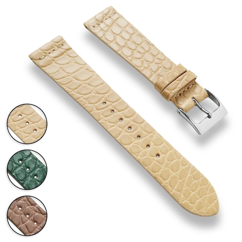 May include: A light beige leather watch strap with a crocodile pattern. The strap has a silver buckle and is shown on a white background.