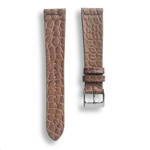 May include: A brown leather watch strap with a crocodile pattern.