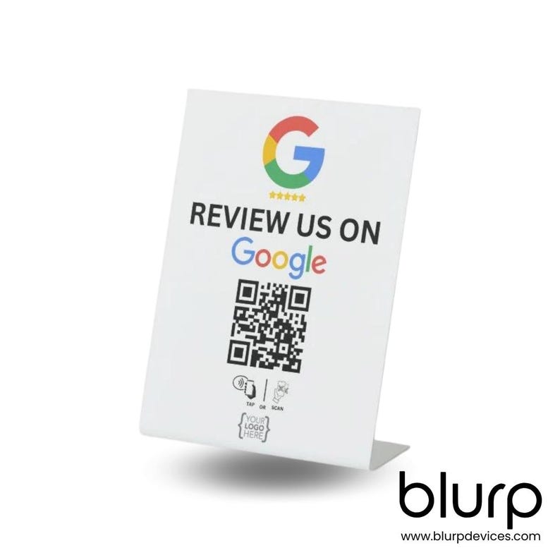 May include: White tabletop sign with a Google logo, the text "REVIEW US ON Google", a QR code, and the text "TAP OR SCAN YOUR LOGO HERE". The sign has a white base with the text "blurp www.blurpdevices.com".