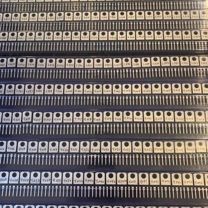 May include: A close-up view of a grid of small, silver-colored electronic components, each labeled with a number. The components are arranged in rows and columns, and they are all mounted on a black plastic base.