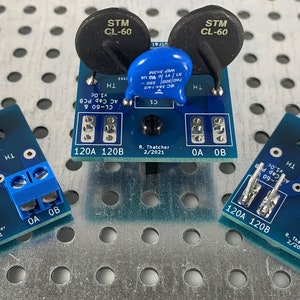 May include: Three blue circuit boards with silver and black components. The boards have the text "120A 120B" and "R. Thatcher 2/2021" printed on them. The boards have screw terminals labelled "TH", "OA", and "OB".