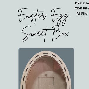 May include: A wooden Easter egg-shaped box with a cutout for a sweet treat. The box is brown and has a decorative border. The text "Easter Egg Sweet Box" is written above the box.
