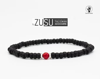 May include: Black beaded bracelet with a single red bead and silver accents. "ZUSU by HANDMADE TALISMAN ACCESSORIE" is printed on the image.