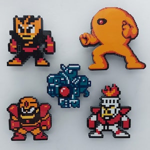 May include: Five pixel art character pins featuring a red and black robot, a yellow robot, a blue and red robot, a red and white robot, and a blue and red robot.