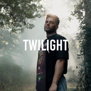 May include: A man wearing a black t-shirt with a graphic print and blue jeans stands in a foggy forest. The text "TWILIGHT" is written in white letters on a black background.