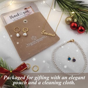 a necklace, earrings, and card on a white sheet