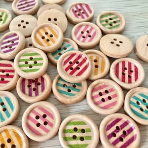 Puede incluir: Surtido de botones de madera con patrones de rayas coloridas. Los botones tienen cuatro agujeros y miden aproximadamente 2,5 cm de diámetro.