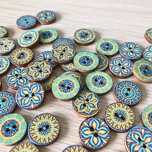 May include: Assortment of wooden buttons with blue and yellow mandala designs.