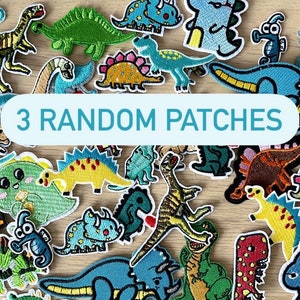 Op de afbeelding: Een verzameling kleurrijke geborduurde strijkpatches met verschillende dinosaurusontwerpen. De patches zijn perfect om kleding, tassen of andere accessoires een leuke en eigenzinnige touch te geven. De tekst "3 RANDOM PATCHES" wordt weergegeven op een blauwe achtergrond.