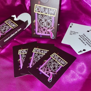 K&ouml;nnte beinhalten: Ein Kartenspiel namens "Draw and Go Lick". Die Karten sind schwarz mit neongelbem und pinkfarbenem Text. Die Schachtel f&uuml;r das Spiel ist schwarz mit neongelbem und pinkfarbenem Text. Die Karten haben ein neongelbes und pinkfarbenes Schild mit der Aufschrift "Draw and Go Lick".
