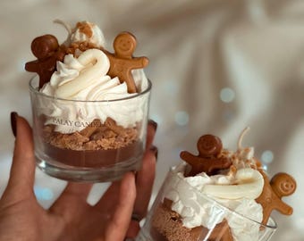 Pode incluir: Dois frascos de vidro cheios de uma sobremesa em camadas. A camada inferior é um molho de chocolate marrom, a camada intermediária é um creme de leite batido branco e a camada superior é um biscoito de gengibre em forma de homem. Os frascos são etiquetados com "Palay Candella".