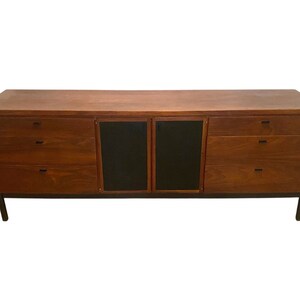 May include: A mid-century modern dresser with a wood top and black doors. The dresser has six drawers, three on each side of the doors.