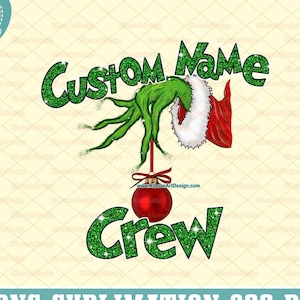 May include: A digital design featuring a green Grinch-like hand holding a red ornament with the text "CUSTOM NAME CREW". The design includes a Santa hat and the words "PNG SUBLIMATION 300 DPI".