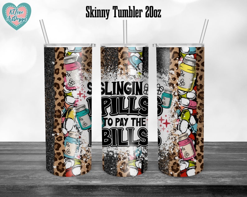 May include: A black and white tumbler with a leopard print design and the text "Slingin' Pills to Pay the Bills". The tumbler is filled with colorful pills and has a white glitter background.