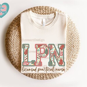 May include: A white t-shirt featuring a colourful patchwork design spelling out "LPN" and the text "licensed practical nurse".