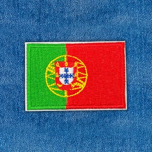 Puede incluir: Parche bordado con la bandera de Portugal. El parche rectangular tiene una franja vertical verde a la izquierda y una franja vertical roja a la derecha. El centro presenta el escudo de armas portugués, rodeado por un círculo amarillo.
