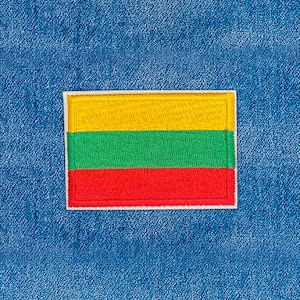 May include: Embroidered patch featuring the flag of Lithuania. The flag design includes horizontal stripes of yellow, green, and red, outlined with a white border. The patch is set against a textured blue denim background.