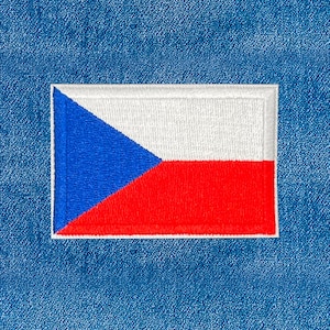 Op de afbeelding: Geborduurde patch met de vlag van Tsjechië. De rechthoekige patch heeft een wit bovenstuk, een rood onderstuk en een blauwe driehoek aan de linkerkant. Geplaatst tegen een blauwe denim achtergrond.