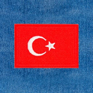 May include: A rectangular patch featuring the flag of Turkey, set against a blue denim background. The flag is red with a white crescent moon and star emblem. The patch is likely an iron-on or sew-on emblem.